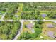 An aerial view of a beautiful community with a home featuring a fenced yard, pergola, fire pit, and an above-ground pool at 2679 Armenia Rd, North Port, FL 34286