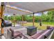 Backyard patio featuring stylish seating under a pergola, with a swing, fire pit, and distant pool at 2679 Armenia Rd, North Port, FL 34286