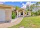 Charming home exterior featuring a well-manicured lawn, walkway, tropical landscaping and an attached garage at 2679 Armenia Rd, North Port, FL 34286