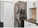 Efficient laundry area featuring stacked washer and dryer units with granite countertop and white cabinets at 2679 Armenia Rd, North Port, FL 34286