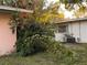 View of the backyard showcasing the exterior of the home with lush greenery and an AC unit at 2911 Novus St, Sarasota, FL 34237