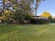 The house has a spacious green lawn and mature trees at 2911 Novus St, Sarasota, FL 34237