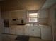 Kitchen features laminate countertops, white cabinets, and a stainless steel sink under a window at 2911 Novus St, Sarasota, FL 34237