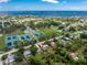 Aerial view of property, showing a well-maintained home surrounded by lush greenery and nearby tennis courts at 348 W Wentworth St, Englewood, FL 34223