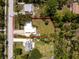 Aerial view reveals a single-story home with a vast lawn area and a quiet, tree-lined neighborhood street at 348 W Wentworth St, Englewood, FL 34223
