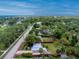 Aerial view showcases a charming single-story home, verdant landscaping, and neighborhood with water view in the distance at 348 W Wentworth St, Englewood, FL 34223