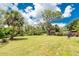 Expansive backyard with lush green lawn, mature trees, and a storage shed, offering plenty of space at 348 W Wentworth St, Englewood, FL 34223