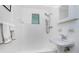 Bathroom with shower, pedestal sink, and tiled walls at 348 W Wentworth St, Englewood, FL 34223