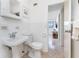 Bathroom with toilet, pedestal sink, and a view through the doorway at 348 W Wentworth St, Englewood, FL 34223