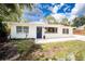 Charming home exterior with a new dark blue front door, modern windows, and tidy landscaping at 348 W Wentworth St, Englewood, FL 34223