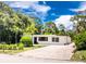 Charming home exterior with a new dark blue front door, modern windows, landscaping, and a gravel driveway at 348 W Wentworth St, Englewood, FL 34223