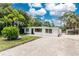 Charming single-story home features a gravel driveway, mature trees, and a well-maintained exterior at 348 W Wentworth St, Englewood, FL 34223