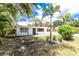 Charming home exterior featuring a new dark blue front door, modern windows, and lush landscaping at 348 W Wentworth St, Englewood, FL 34223