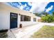 Inviting front entrance with a blue door, brick walkway, and lush landscaping, creating curb appeal at 348 W Wentworth St, Englewood, FL 34223