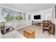 Bright living room featuring large windows, a comfortable sofa, and a dining area at 348 W Wentworth St, Englewood, FL 34223