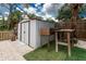 Backyard shows a metal shed with double doors for garden equipment storage, next to a wooden potting table at 348 W Wentworth St, Englewood, FL 34223