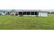 Backyard featuring solar panels on home, wooden deck, and screened in porch. Chain link fence is also featured at 39 Caddy Rd, Rotonda West, FL 33947
