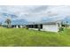 Backyard featuring solar panels on home, screened in porch, and cactus landscaping. Chain link fence is also featured at 39 Caddy Rd, Rotonda West, FL 33947
