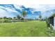 Picture of backyard featuring a pond, palm trees and well kept grass. Chain link fence is also featured at 39 Caddy Rd, Rotonda West, FL 33947