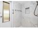 Updated bathroom shower with marble-look tile, shower caddy and glass door at 39 Caddy Rd, Rotonda West, FL 33947