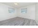 A bright bedroom with two windows and light gray laminate floors at 39 Caddy Rd, Rotonda West, FL 33947