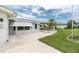 Charming house with a well-kept lawn, front patio, awning-covered windows, blue front door and desert landscaping at 39 Caddy Rd, Rotonda West, FL 33947