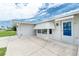 Exterior featuring a blue entry door with awning, concrete patio, and windows with hurricane awning at 39 Caddy Rd, Rotonda West, FL 33947
