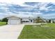 Charming single-story home with an attached garage, well-manicured lawn, and a delightful landscaped flowerbed at 39 Caddy Rd, Rotonda West, FL 33947