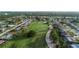 Beautiful aerial view of homes bordering a wide-open green golf course and community lake at 39 Pine Valley Ct, Rotonda West, FL 33947