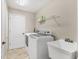 Functional laundry room with modern washer and dryer, utility sink, and ample space at 39 Pine Valley Ct, Rotonda West, FL 33947