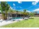 The spacious fenced-in yard features a screened-in pool and tropical landscaping at 4221 Ulster Ave, North Port, FL 34287