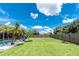 Spacious backyard featuring a well-maintained lawn, privacy fence, and lush tropical landscaping at 4221 Ulster Ave, North Port, FL 34287