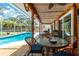 Outdoor covered dining offers a cozy dining spot with views of the inviting pool and backyard at 4221 Ulster Ave, North Port, FL 34287