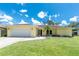 Charming single-story home with a manicured lawn, light yellow exterior, and a well-maintained two car garage at 4221 Ulster Ave, North Port, FL 34287
