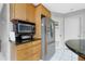 Functional kitchen featuring stainless steel refrigerator and microwave, plus a convenient countertop at 4221 Ulster Ave, North Port, FL 34287