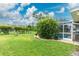 Lush green backyard featuring a pool with screen enclosure and well-maintained landscaping at 4227 Winona St, Port Charlotte, FL 33948