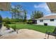 Spacious backyard featuring a screened-in patio, lush lawn, and decorative landscaping at 4227 Winona St, Port Charlotte, FL 33948
