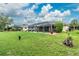 Expansive green backyard with a glimpse of the inviting pool, enhanced by vibrant landscaping and lush greenery at 4227 Winona St, Port Charlotte, FL 33948