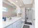 Bathroom with a white vanity, toilet, a tiled shower with glass door, and marble-look walls at 4227 Winona St, Port Charlotte, FL 33948