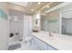 Bright bathroom featuring a walk-in shower with tile surround and vanity with quartz counters and storage at 4227 Winona St, Port Charlotte, FL 33948