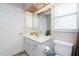 Bathroom with a vanity, toilet, window with blinds, and storage cabinets at 4227 Winona St, Port Charlotte, FL 33948