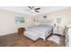 Bedroom with wood floors, ceiling fan, bed, bench, side tables, and windows at 4227 Winona St, Port Charlotte, FL 33948