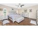 Bedroom featuring wood floors, ceiling fan, bed, bench, side tables, windows and area rug at 4227 Winona St, Port Charlotte, FL 33948