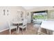 Cozy dining area with a modern light fixture, white table, and a view of the backyard pool at 4227 Winona St, Port Charlotte, FL 33948