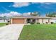 Inviting home with a well-kept lawn, brown garage door, and manicured shrubbery at 4227 Winona St, Port Charlotte, FL 33948