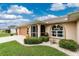 Charming home with a well-manicured lawn, a decorative landscape, and a tan-colored exterior at 4227 Winona St, Port Charlotte, FL 33948