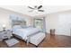 Comfortable main bedroom with wood floors, ceiling fan, sliding doors, and a gray upholstered bed frame with stylish bedding at 4227 Winona St, Port Charlotte, FL 33948