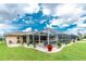 Gorgeous backyard showcasing a screened pool area, lush landscaping, and ample space for outdoor enjoyment at 4227 Winona St, Port Charlotte, FL 33948