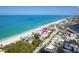 Aerial shot of a building next to a white sand beach, with turquoise water and residential area at 50 Meredith Dr # 9, Englewood, FL 34223