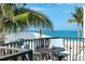 Balcony view showcasing ocean views, a table with blue padded chairs and coastal decorations at 50 Meredith Dr # 9, Englewood, FL 34223